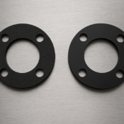 Junta de EPDM celular y junta de EPDM compacto sobre una superficie de acero inoxidable, mostrando claramente la diferencia de textura entre ambos materiales.